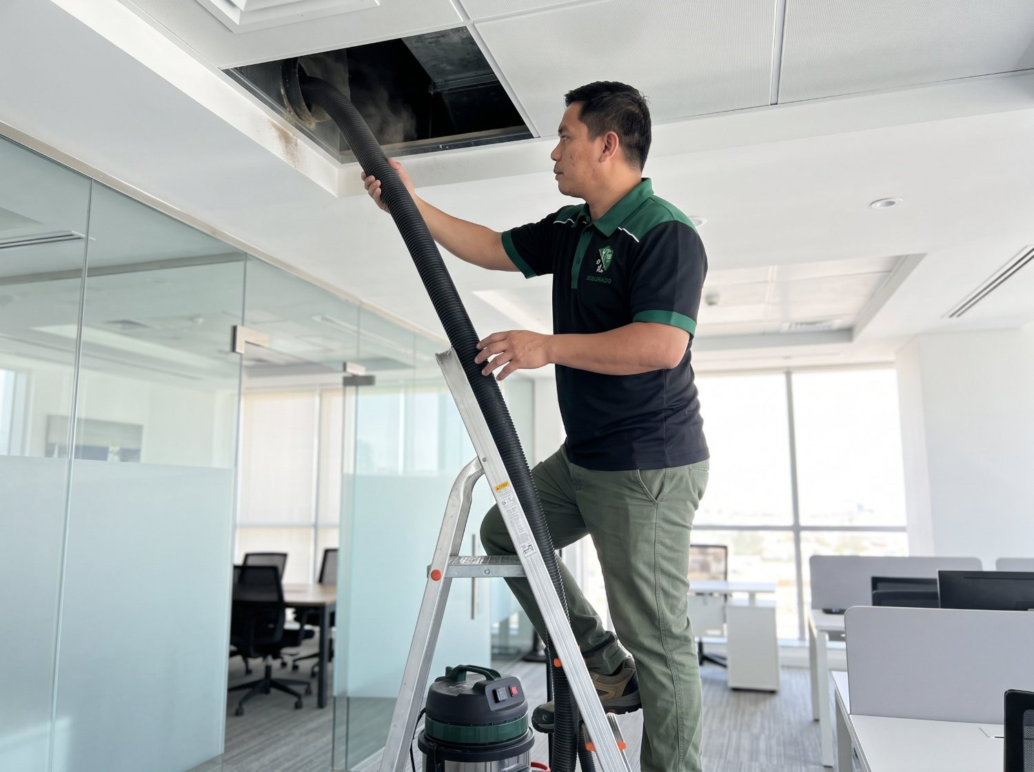 Segurado technician vacuuming a ceiling air duct